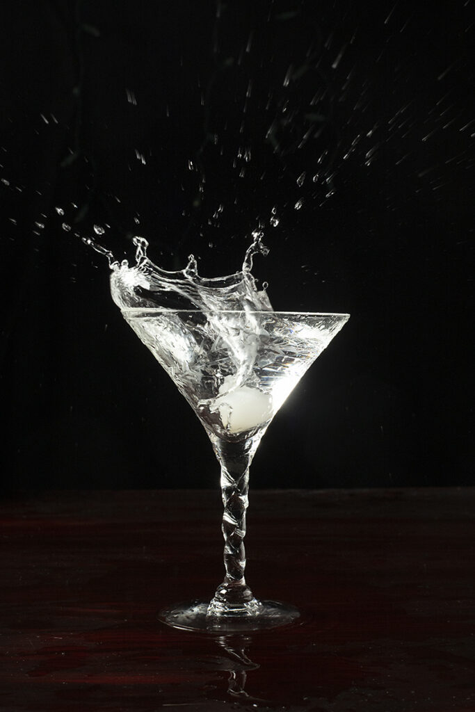 a cocktail onion splashing into a martini 