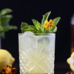 yellow cocktail with mint and a yellow flower