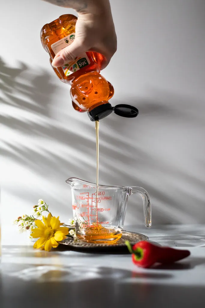 squeezing honey into a measuring cup