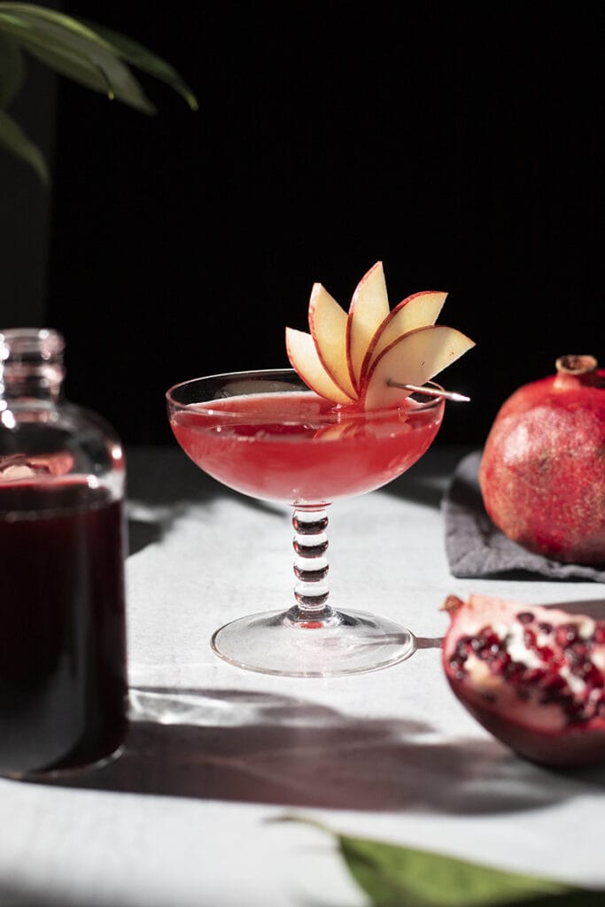red cocktail next to pomegranate