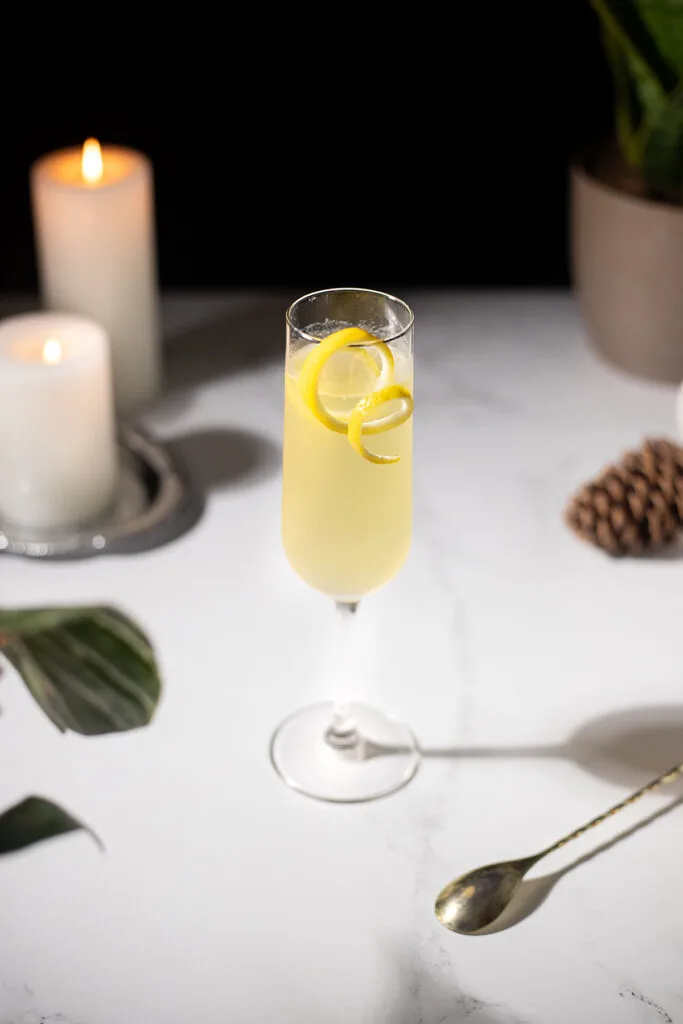 a white table with candles and a yellow champagne cocktail.