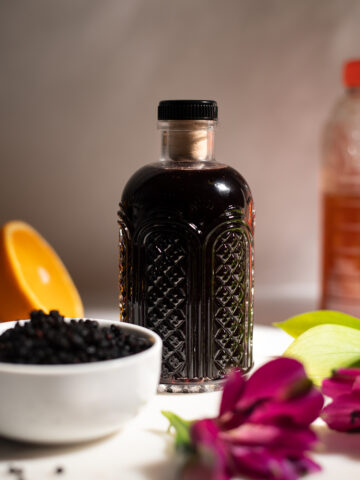 dark purple syrup in a small etched glass bottle.